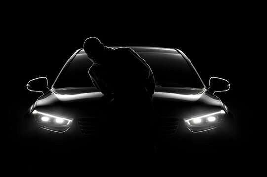 Man sitting in a black luxury car holding car keys