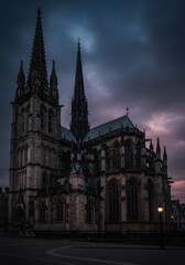 Fototapeta premium Gothic cathedral at twilight, moody clouds and detailed stonework