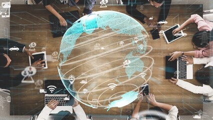 A diverse group engages in collaboration around a modern table with various devices, featuring a digital globe overlay representing global connectivity and innovation. Xenic