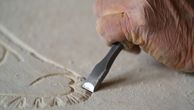 Artisan carving stone relief workshop craftsmanship indoor close-up traditional skills