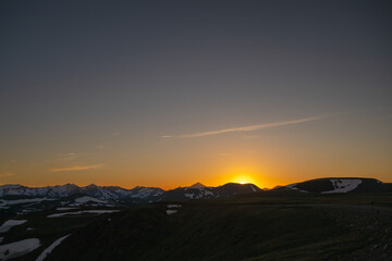 Sun Disappears Behind Snowy Ridges Of Rocky Mountain