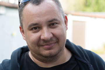 A portrait of a 40-year-old man on a city street.