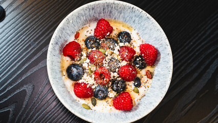 Nutritious yogurt parfait with fresh raspberries, blueberries, oats, chia seeds and honey drizzle. Perfect for healthy food blogs and breakfast photography.