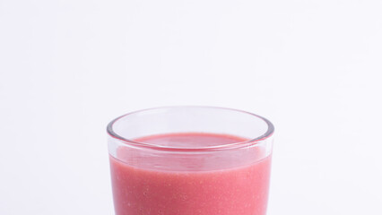Close up of a glass of fresh pink guava juice on a white background. Healthy tropical drink, natural detox beverage, vitamin-rich smoothie, refreshing and isolated for food concepts.
