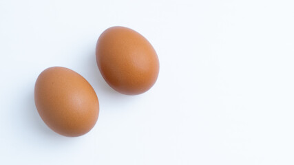 Two brown chicken eggs with copy space on a white background. Concepts for food, ingredient, protein, healthy, breakfast, organic, cooking, fresh, isolated, pair.
