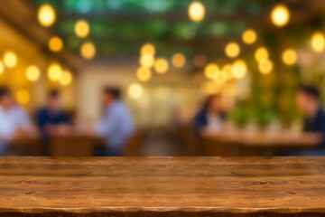 Empty wooden table  bokeh light background. Tables and chairs in the lobby of restaurant. Visitors to restaurant for dinner. Cozy bokeh lightening. Beautiful bright interior. Blurred bokeh basic