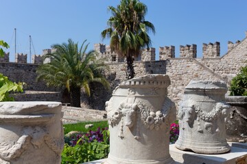 Historical artifacts are displayed in a garden at Castle. Ornate stone vases sit in the foreground,...