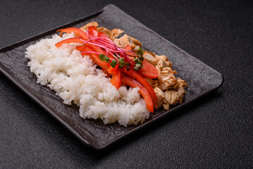 Bowl with chicken pieces, rice, tomatoes, peppers and microgreens. Bowl with chicken