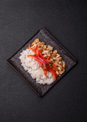 Bowl with chicken pieces, rice, tomatoes, peppers and microgreens. Bowl with chicken