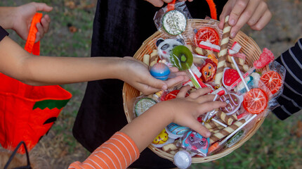 Fototapeta premium Children collecting candy for Halloween. Selective focus