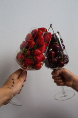 two glasses with cherries and strawberries