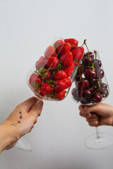 two glasses with cherries and strawberries