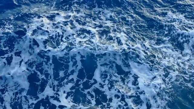Deep blue  sea surface with waves and foam in motion 