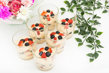 Sweet dessert in glasses with creme brulee and fresh berries on birthday table