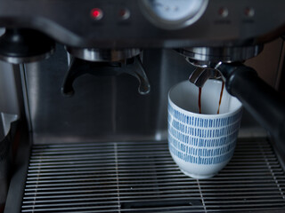 Espresso Coffee Pouring into Cup from Coffee Machine
