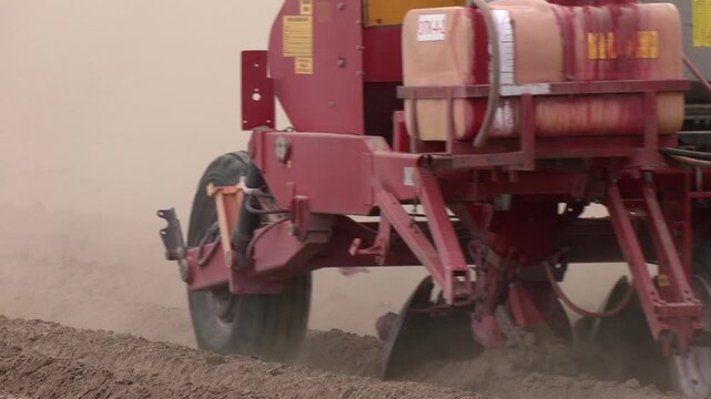 Spring Sowing in the Field With Modern Mechanisms. A tractor planting a potato crop on the prairies. 