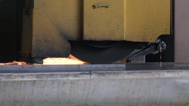 Work of an industrial surface grinding machine. Grinding of a flat metal part. Sparks fly out from under the grinding wheel.  Processing of metal by grinding on a flat grinding machine
