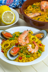 Plato y cazuela con paella de arroz y marisco