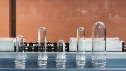 PETG plastic preforms for bottle making on the conveyor belt before the hot blow molding machine