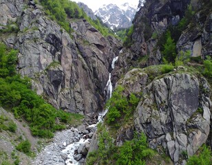 Mountain waterfall cascading down rocky gorge