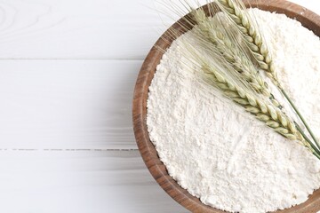 Flour and green wheat spikes in bowl on white wooden table, top view. Space for text