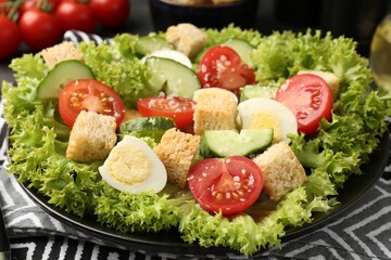 Delicious salad with croutons, chicken, quail eggs, vegetables and cheese on table, closeup