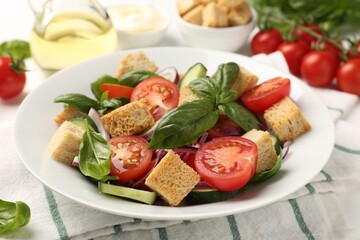Delicious salad with croutons and ingredients on table, closeup