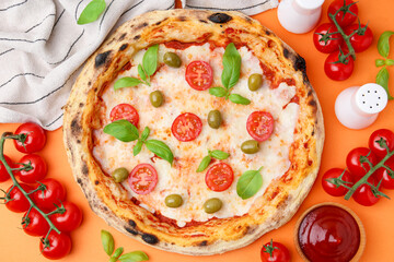 Delicious pizza and ingredients on orange background, flat lay
