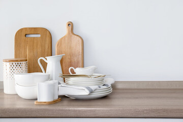 Different clean white dishware and cutting boards on counter in kitchen. Space for text
