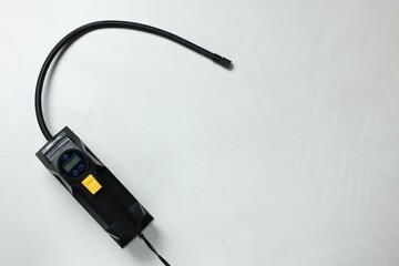 Obraz premium One tire inflator on light background, top view. Space for text