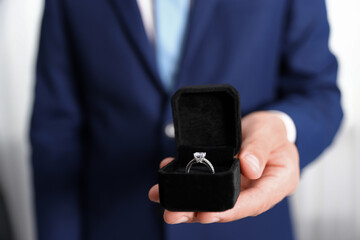 Making proposal. Man with engagement ring indoors, closeup