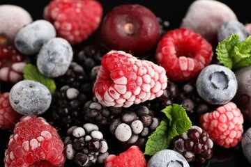 Many different frozen berries and mint on table, closeup