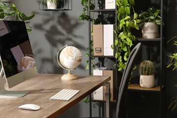 Biophilic interior design. Stylish workplace with computer and houseplants in office