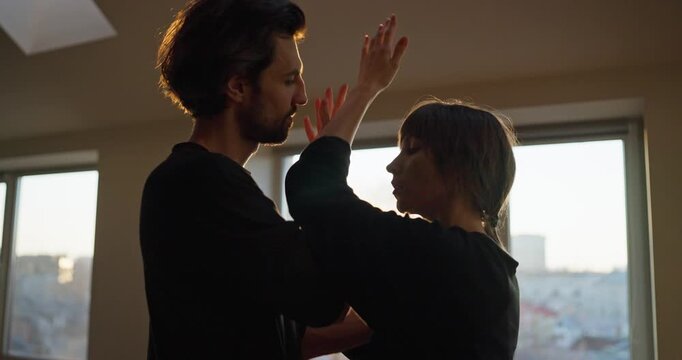 Romantic couple dancing at sunset in cozy loft apartment with natural light and connection concept in modern lifestyle and mindfulness atmosphere