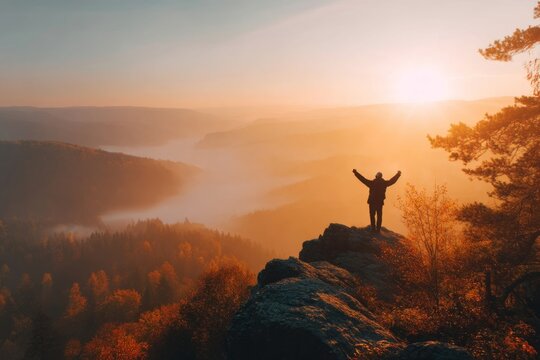 Silhouette of hiker on mountain peak at sunrise