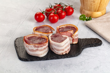 Raw pork tenferloin with bacon