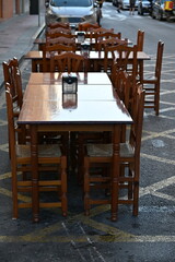 puste drewniane stoły i krzesła na ulicy przed restauracją