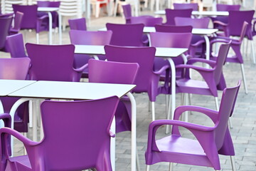 puste fioletowe krzesła i białe stopy w ogródku restauracyjnym