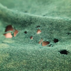 closeup there is so many hole on the broken old green bamboo cotton clothes texture like eat by bug