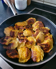 Top view of homemade roasted varenyky on the pan. Varenyky, filled dumplings, is a national Ukrainian dish. The cooking option is appetizing roasted varenyky.