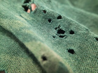 closeup there is so many hole on the broken old green bamboo cotton clothes texture