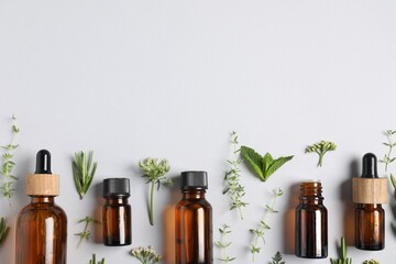 Essential oils and different plants on white background, flat lay. Space for text