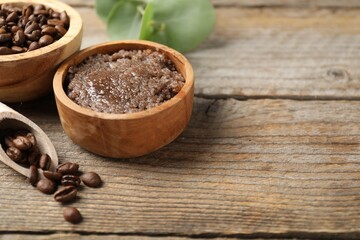 Natural body scrub and coffee beans on wooden table, closeup. Space for text