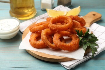 Fried squid rings served on light blue wooden table, closeup