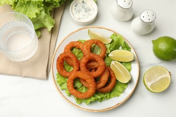 Fried squid rings served on white marble table, flat lay