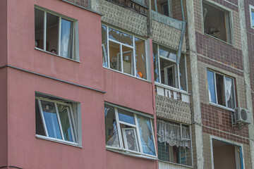 Fototapeta premium Facade of a residential building with broken windows after shelling