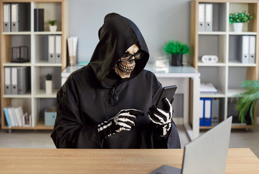 Smartphone thefts, robberies, scary dangerous hacker Halloween Grim Reaper horrific figure masked secret man with phone, financial criminal of digital wallet fraud, disaster, fake investment manager