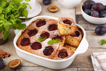 Sponge cake with plums, cinnamon and brown sugar. Delicious homemade sweet pie with seasonal fruits. 