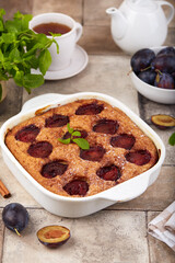 Sponge cake with plums, cinnamon and brown sugar. Delicious homemade sweet pie with seasonal fruits. 