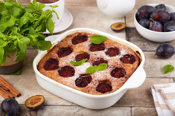 Sponge cake with plums, cinnamon and brown sugar. Delicious homemade sweet pie with seasonal fruits. 